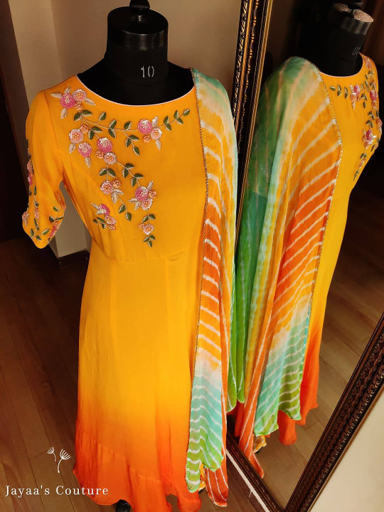orange shaded Gown Paired up with Leheriya Dupatta.