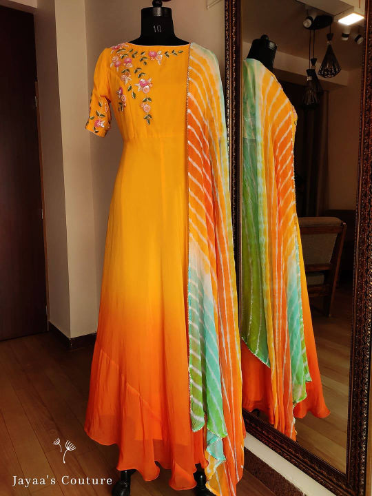 orange shaded Gown Paired up with Leheriya Dupatta.